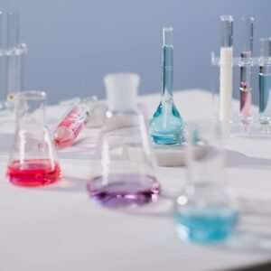Vibrant liquids in glassware on a laboratory table in a modern science setting.